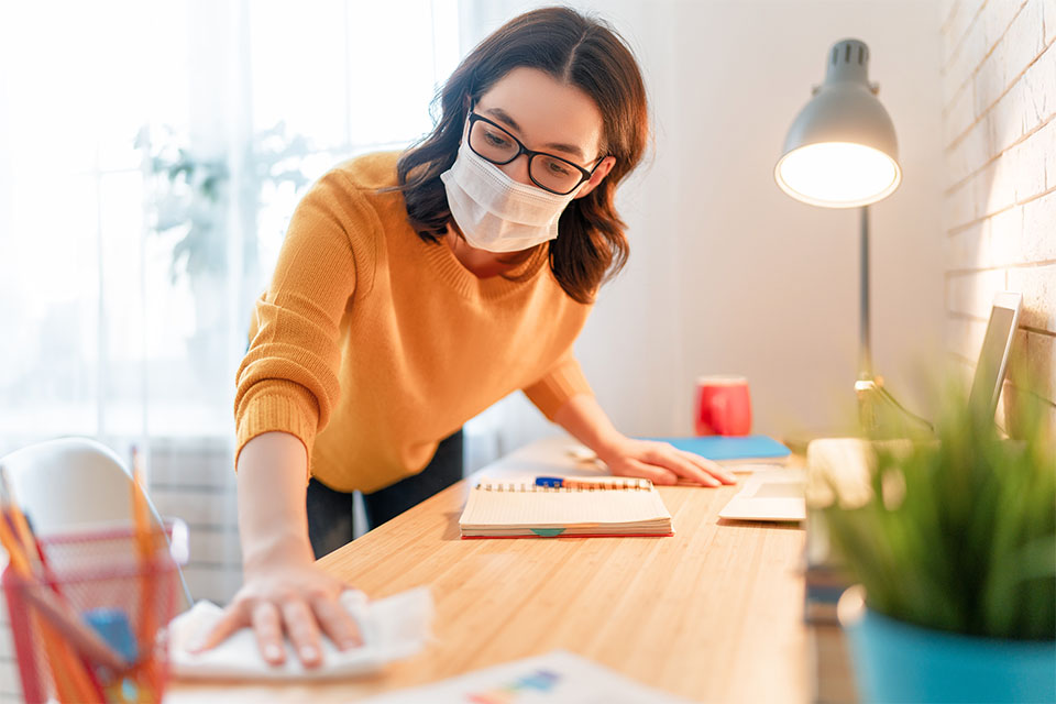 Woman wipes down desk.