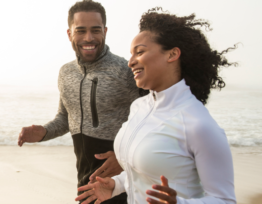 Couple goes for run on beach.