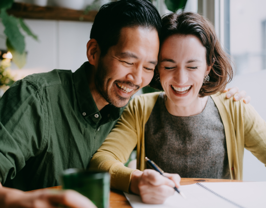 Man and woman work together at table.