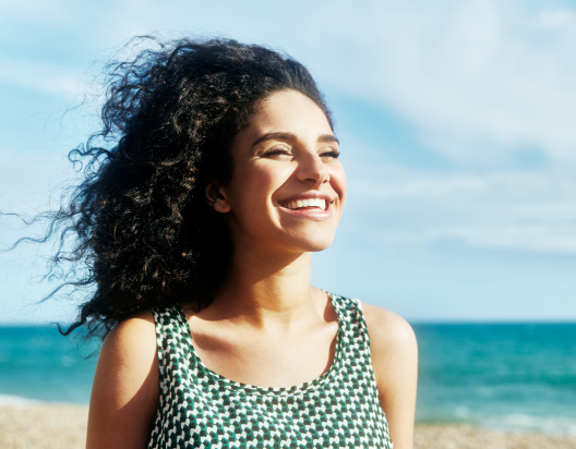 Woman enjoys a sunlit beach. 