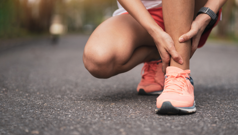 Jogger massages own ankle.