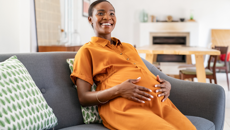 Woman feels her pregnant belly.