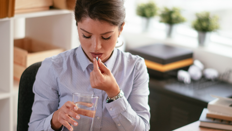 Woman takes vitamin supplement.